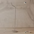 Modern Floor Lamp With Slim Metal Pole On Wooden Tabletop And Neutral Wall