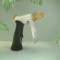 Handheld Household Tool With Black Handle Silver Metal And Wooden Nozzle Against Green Leaves Background