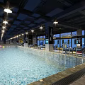 Modern Indoor Swimming Pool With Blue Water Ceiling Lights Large Windows And City View