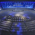 Modern Large Conference Venue With Stage Arranged Seats And Blue Lighting