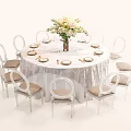 Elegant Round Dining Table Set With White Tablecloth Flower Vase And Cushioned Chairs