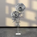 Decorative Floral Installation With Large Flowers Metallic Stems Leaves White Base Light Shadow Background