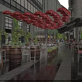 Commercial Street with Outdoor Dining Area Red Umbrellas Wooden Barrels Tables Chairs and Green Plants