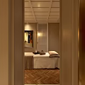 Elegant SPA Room With Massage Table Stool Paintings On Walls Herringbone Floor And Ceiling Lights