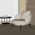 Beige Fabric Accent Chair With Black Legs By Window And Round Side Table With Books