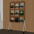 Wooden Tiered Bookcase With Wheels Holding Books Frames By Wooden Wall Window With Blinds