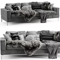 Cozy Gray Three Seater Sofa With Decorative Pillows And Faux Fur Throws