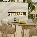 Terrace Dining Table And Wicker Chairs With Green Plants And Wall Lighting
