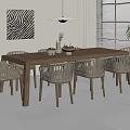 Long Wooden Outdoor Table with Woven Chairs and Decorative Items Near Window and Potted Plant