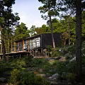 Modern Forest House With Wooden Deck Surrounded By Trees And Natural Landscape