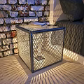 Cube Shaped Metal Mesh Floor Lamp On Sofa Side With Light Shadows And Brick Wall