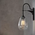 Vintage Black Metal Wall Sconces With Clear Glass Shades And Filament Bulbs On Gray Wall