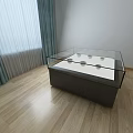 Display Showcase Shelf with Glass Top Dark Base and Display Items on Wooden Floor