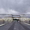Modern Commercial Complex Exterior With Curved Glass Walls Open Plaza And People Walking