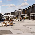 Charming Commercial Street Featuring Outdoor Cafes Pedestrians And Modern Shop Designs