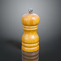 Yellow Wooden Pepper Grinder With Wood Grain And Metal Top Knob On Black Surface