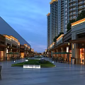 Evening Modern Commercial Street With High Rise Buildings Shops Greenery Plaza and Lighting