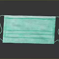 Green Three Layer Face Mask With Ear Loops Featuring Reflection On Black Background