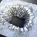 Square Stone Pit With Rough Stone Walls Dirt Bottom And Surrounding Gravel