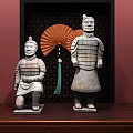 Terracotta Warrior Sculptures Kneeling And Standing With Red Fan And Dark Frame On Wooden Table