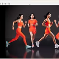 Four Women Running in Bright Orange Sportswear Against Dark Background