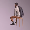 Smiling Man Sitting on Wooden Chair in Gray Sweater Scarf and Brown Pants