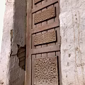Traditional Building Exterior Wall with Intricate Carved Wooden Door and Rough Texture