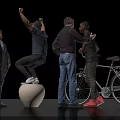 Four People Interacting with Bicycle and White Sphere While Standing and Raising Hands