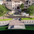 Modern Residential Area Landscape With White Buildings Trees Green Lawns And Stone Pathways
