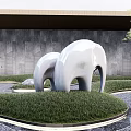 White Abstract Elephant Sculpture in Outdoor Garden With Green Grass And Gray Stone Wall