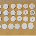 White Decorative Ceiling Light Plates With Various Patterns Arranged On Brown Background 3d model