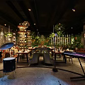 Modern Restaurant Interior With Green Plants Dining Tables Chairs Hanging Lights And Live Music