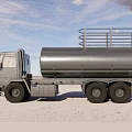 Silver Tanker Truck with Metal Rails on Sandy Ground Under Blue Sky