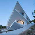 Modern Geometric Single Family Villa With White Roof Large Windows And Hillside Rocky Landscape