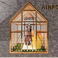 House Shaped Shop Window with Golden Frame featuring Mannequin in Brown Coat and Yellow Bucket