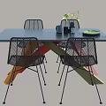 Black Dining Table Set Featuring Colorful Cross Legs Black Rattan Chairs and Green Plant Decor