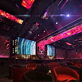 Modern Bar Interior with Neon Lights Stage Screens and Seating Area