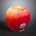 Fresh Ripe Red Apple With Sticker On Dark Reflective Surface