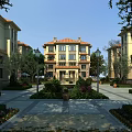 European Style Multi story Residential Building With Red Tile Roof Lush Gardens And Street Lamps
