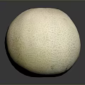 Fresh Cantaloupe With Textured Light Yellow Skin On Dark Reflective Surface