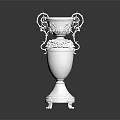 White Decorative Vase With Ornate Handles And Carved Floral Details On Pedestal Base