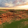 Stunning Red Rock Landscapes With Green Grass Under Sunset Sky And Clouds