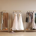 Clothes Racks Holding Different Dresses Gowns Shoes and Hat in Indoor Area with Light Wall