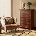 Beige Single Sofa With Patterned Cushion Near Small Side Table Wooden Dresser on Checkered Rug