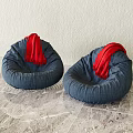 Two Blue Bean Bag Chairs With Red Scarves On Marble Floor And Light Wall