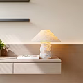 Modern Stone Base Table Lamp On Wooden Shelf With Green Plant And Books