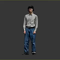 Man in Light Long Sleeve Shirt and Blue Jeans Standing with Headphones Against Gray Background