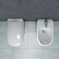 Sleek Modern White Toilet In Bathroom With Gray Walls And Light Colored Floor