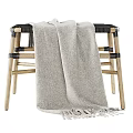 Wooden Stool With Black Seat And Beige Fringed Blanket Draped Over