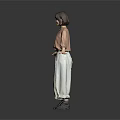 Woman in Brown Top and Beige Pants with Arms Outstretched on Gray Background